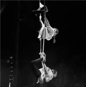 Zwei junge Künstler führen während eines Kurses an der Max & Maurice Circus Arts School in Colombelles eine Luftakrobatiknummer am Seil unter einem Zirkuszelt vor.