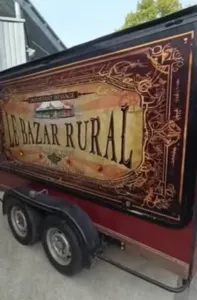 Künstlerisch gestalteter Anhänger des Rural Bazaar, verziert mit einem großen Vintage-Wandgemälde in Zirkusfarben, diente zur Werbung für die Reiseaktivitäten des Vereins in Dörfern und für kulturelle Veranstaltungen.