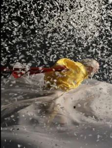 In einer ikonischen Szene aus Slavas Schneeshow kämpft ein in Gelb gekleideter Clown gegen einen gewaltigen Schneesturm und Konfetti.