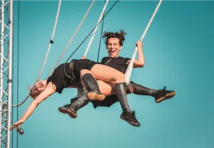 Twee artiesten van het gezelschap Lady Cocktail voeren een spectaculaire luchtacrobatiekact op in de show De la Mort qui Tue.
