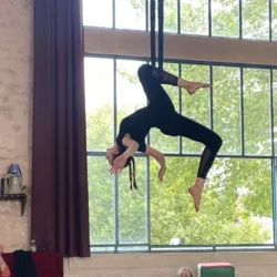 Circusartiest, hangend aan zijden doeken, voert een acrobatische act uit tijdens een training aan de Nationale Circusschool van Châtellerault.