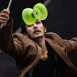 Yohan Durand in full diabolo performance with two sticks, performing a spectacular figure during his juggling, dance and theatre show "It's silly but it sticks to the skin".
