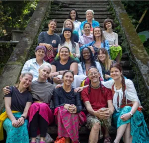 Group photo of the participants, speakers and organizers of the Hoop Dream Retreat gathered on an outdoor staircase in the heart of the Balinese tropical vegetation.