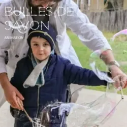 A young child participates in a science workshop about soap bubbles with an instructor wearing a white lab coat. The child manipulates a large frame to create a huge soap bubble. The title "Soap Bubbles - Animation" appears.