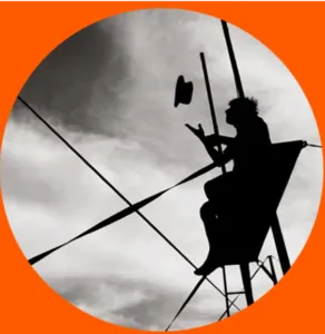 Silhouette d'un artiste de cirque assis en hauteur sur une structure aérienne lançant son chapeau dans un ciel nuageux, visuel emblématique de l'association L'Art d'En Faire.