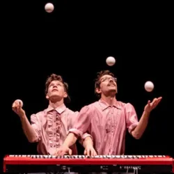 Twee artiesten van het Sombra Company jongleren met verschillende ballen rond een piano, een symbool van de ontmoeting tussen hedendaags jongleren en klassieke muziek.