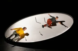 Jonathan Guichard en Lauren Bolze in Thaumazein, een hedendaagse circusvoorstelling van Compagnie HMG, die optreedt op een spectaculaire, beweegbare tol met een diameter van zes meter in het Théâtre de la Cité in Toulouse. Foto © Ian Granjean.
