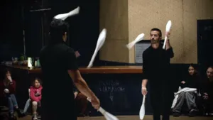 Deux jongleurs de la Compagnie Bêstîa jonglent avec des massues blanches dans le spectacle de cirque Fratello.