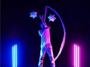 Carlo Cerato op het podium in ASTRAT, een hedendaagse jongleershow die objectmanipulatie, blauw en roze licht, beeldende kunst en elektronische muziek combineert, gepresenteerd in het Théâtre Jean Marais in Saint-Fons.