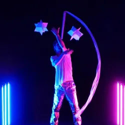 Carlo Cerato op het podium in ASTRAT, een hedendaagse jongleershow die objectmanipulatie, blauw en roze licht, beeldende kunst en elektronische muziek combineert, gepresenteerd in het Théâtre Jean Marais in Saint-Fons.