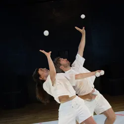 Elsa Guérin et Tom Neyret jonglent avec des balles blanches dans Animale géométrique, spectacle de cirque contemporain de Studio Phantôm mêlant jonglage, danse, mouvements synchronisés et musique répétitive.