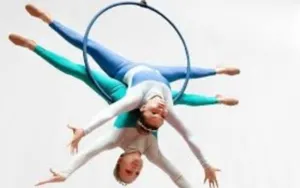 Deux artistes réalisant une figure acrobatique suspendue à un cerceau aérien, illustration des disciplines enseignées par l’école de cirque Les Arts de l’Air à Nice.