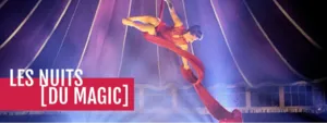 Bannière du spectacle de cirque Les Nuits [du Magic] au CIAM d’Aix-en-Provence, montrant une artiste réalisant une figure aérienne sur tissu rouge sous le chapiteau.
