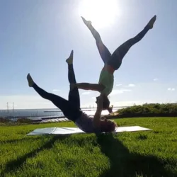 Duo de femmes effecturant une figure d'acroyoga